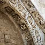 La cornice del timpano � adorna di teste leonine e di pomi traforati intervallati da fogliame di acanto, mentre l'archivolto (decorato nell�intradosso da lacunari con rosette)...